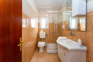 A bathroom with a toilet, shower, and sink. - Drazen Charming First Floor Apartment (Novalja)
