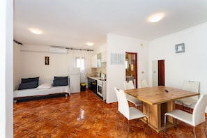A compact living space with a kitchenette, a dining area, and a bed. - Drazen Charming First Floor Apartment (Novalja)