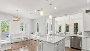 A spacious kitchen with white cabinetry, a central island, and pendant lighting. - Prime Seagrove Location | Private Pool, Bikes, Porches, Steps to Beach Access (Santa Rosa Beach)
