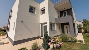 A modern two-story house with a flat roof, large windows, and a small balcony. - Holiday home Galižana (Galižana)