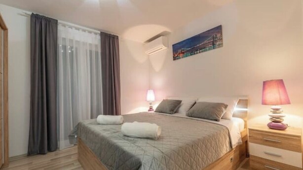 A bedroom with a bed, bedside tables, a lamp, and a painting on the wall. - Holiday home Galižana (Galižana)