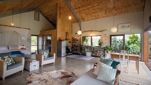 Amplia sala de estar con un sofá grande, una mesa de comedor y una cocina al fondo.