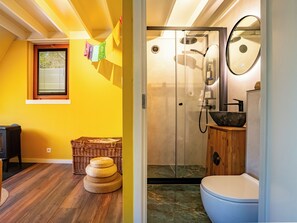A bathroom with a glass door, a round mirror, and a sink with a stone basin. - Boshuisje Rekem Two-Bedroom Houses (Lanaken)