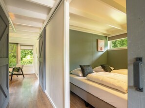 A bedroom with a bed, a chair, and a window. - Boshuisje Rekem Two-Bedroom Houses (Lanaken)