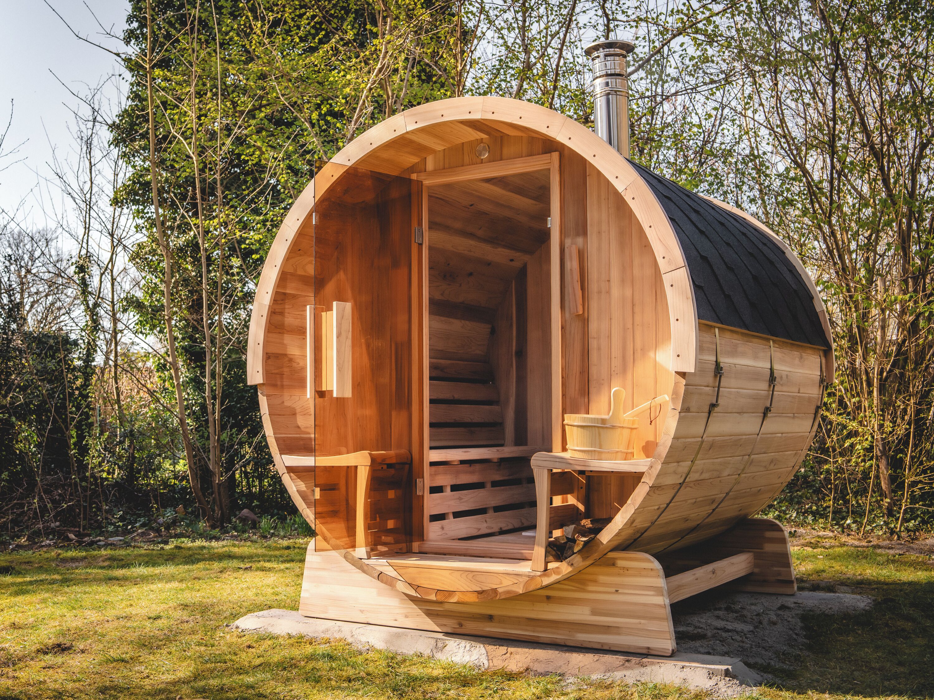 A wooden sauna with a curved exterior, a door, and a small bench inside.