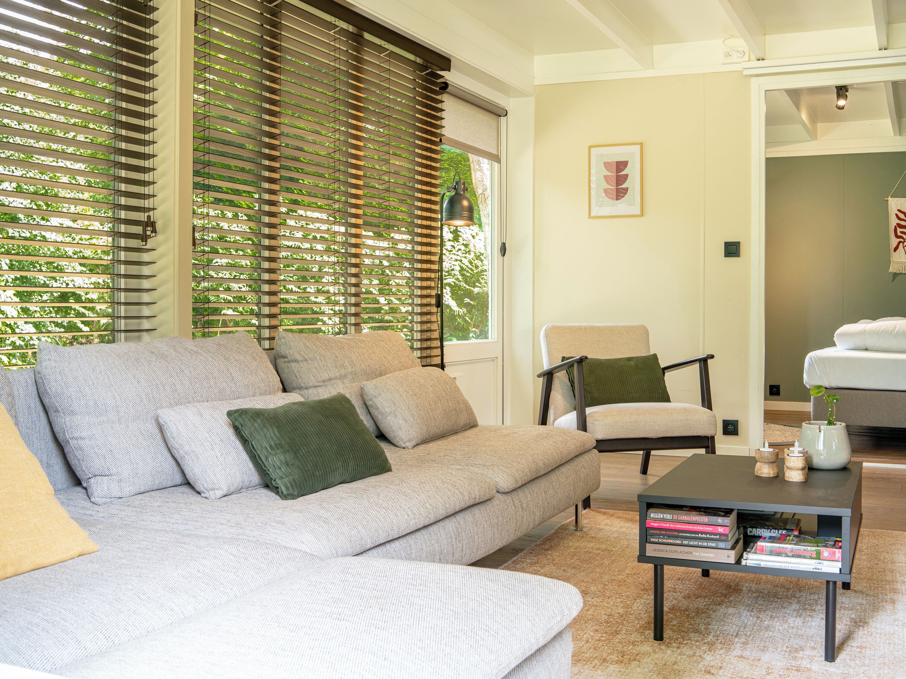 Ein modernes Wohnzimmer mit einer Couch, Sesseln und einem Couchtisch mit Büchern.