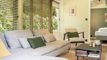 Ein modernes Wohnzimmer mit einer Couch, Sesseln und einem Couchtisch mit Büchern.