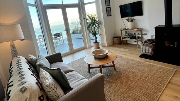 A spacious living room with a sofa, a coffee table, and a fireplace.