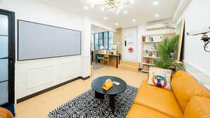 A modern living room with a large whiteboard, a round coffee table, a sofa with a decorative pillow, and a bookshelf. - Shanghai Hills&Zinn Changle road Homestay (Shanghai)