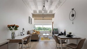 A modern living space with a dining area, a sofa, and a view of greenery. - The Yellow Corporate Suite (Milton Keynes)