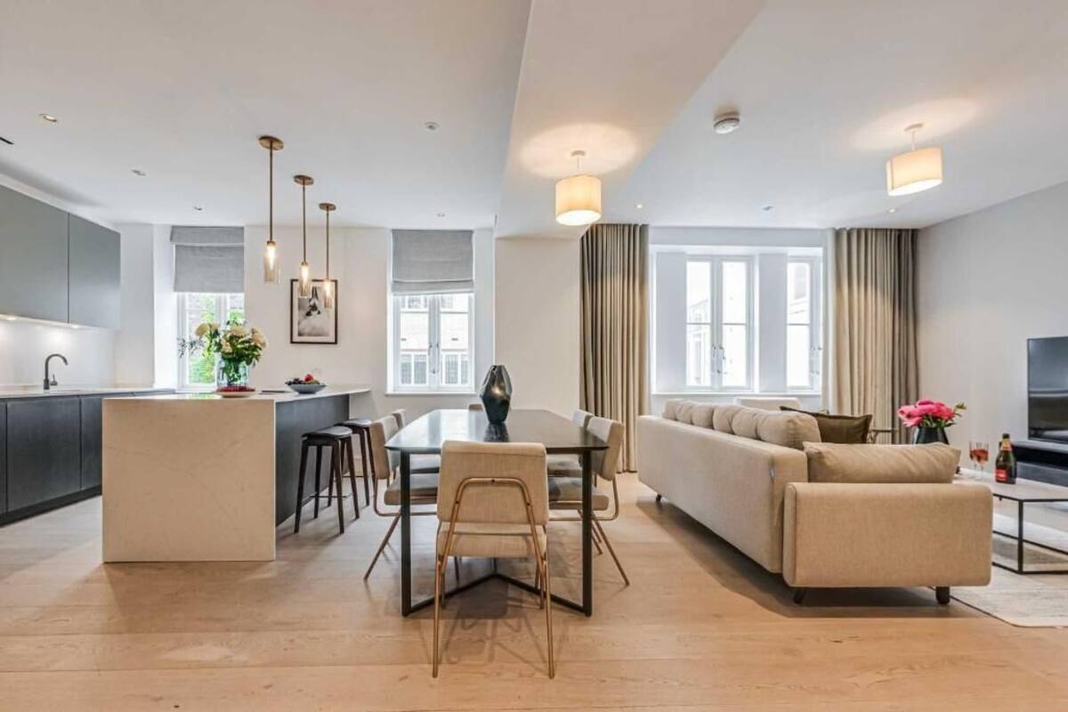 Un salon moderne comprenant un canapé, une table à manger et un coin cuisine.