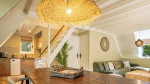 A spacious loft with a wooden dining table, a woven ceiling light, and a staircase leading to an upper level. - Boshuisje Rekem Three-Bedroom Houses (Lanaken)
