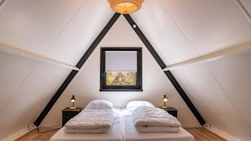 Een knus slaapkamer op zolder met een schuine kap, twee bedden, een raam met uitzicht en een hangende lamp.