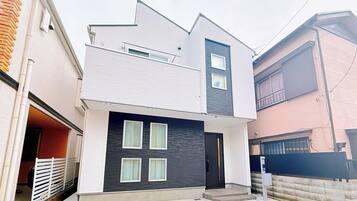 A modern two-story house with a garage, a covered driveway, and a 7-minute walk to the nearest train station.