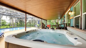 A hot tub area with a wooden ceiling, a pool, and a view of greenery. - Lakefront Home w/ Hot Tub & Dock in Orlando! (Orlando)