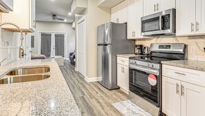 A modern kitchen with stainless steel appliances, granite countertops, and white cabinetry. - Sip, Dine & Explore Fountain Square: Indy Retreat! (Indianapolis)