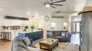 A spacious living area with a gray sofa, a coffee table, and a blue accent wall. - Golf & Hike: Family Home in Rotonda West! (Rotonda West)