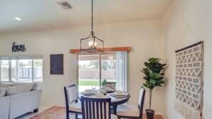 A dining area with a round table, chairs, and a hanging light fixture. - 1 Mi to Golf Course: Yuma Oasis w/ Furnished Patio (Yuma)