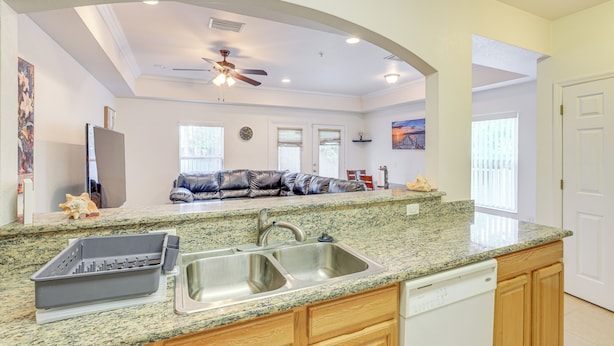 A kitchen with granite countertops, a dishwasher, and wooden cabinets. - 1 Mi to UF! Gator Game Day Retreat w/ Balcony (Gainesville)