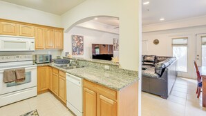 A kitchen with wooden cabinets, a granite countertop, and a built-in oven. - 1 Mi to UF! Gator Game Day Retreat w/ Balcony (Gainesville)