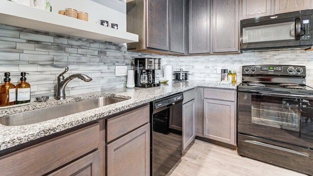 A modern kitchen with granite countertops, stainless steel appliances, and wooden cabinets. - Lake Conroe Home w/ Yard: Half-mi to Boating! (Willis)