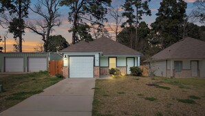 A single-story house with a front garage, a small porch, and a well-maintained lawn. - Lake Conroe Home w/ Yard: Half-mi to Boating! (Willis)