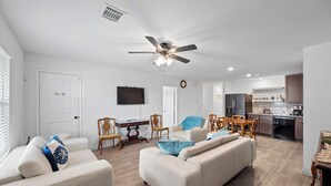 A modern living room with a sofa, chairs, a TV, and a dining area with a table and chairs. - Lake Conroe Home w/ Yard: Half-mi to Boating! (Willis)