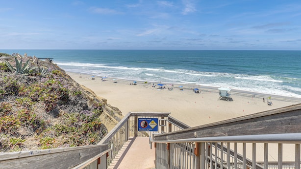A beach with a lifeguard tower, a sign warning of dangerous currents, and a staircase leading down to the beach. - Resort Perks, Ocean Access: Solana Beach Townhome! (Solana Beach)
