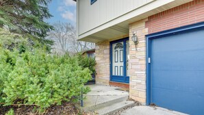 A house with a blue garage door, a front door with a glass panel, and a stone facade. - Deck & Seasonal Pool: Spacious Home Near Buffalo! (Buffalo)