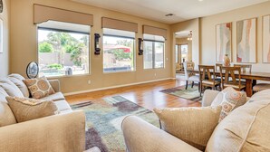 A spacious living room with a large window, a dining area, and a view of the outdoors. - Peoria Desert Oasis < 10 Mi to Spring Training! (Peoria)