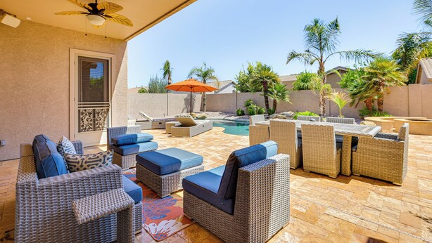 A covered outdoor patio with wicker furniture, a pool, and palm trees. - Peoria Desert Oasis < 10 Mi to Spring Training! (Peoria)