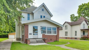 A two-story house with a front porch, a garage, and a well-maintained lawn. - < 1 Mi to Main St: Quiet Apartment in Galesburg! (Galesburg)
