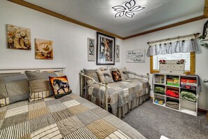 A cozy room with a bed, a bookshelf, and various wall decorations. - Quiet Eagar Retreat Near Lakes, Hiking & Hunting! (Eagar)