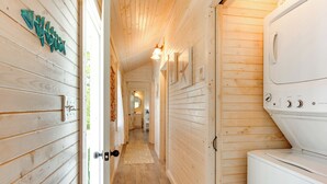 A hallway with wooden walls, a washing machine, and a door with a keyhole. - 2 Mi to Carrabelle Beach: Home w/ Yard & Porch (Carrabelle)