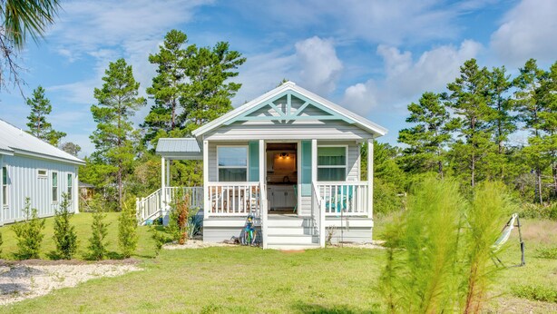 A small, single-story house with a porch and a covered entryway, surrounded by trees and a grassy yard. - 2 Mi to Carrabelle Beach: Home w/ Yard & Porch (Carrabelle)