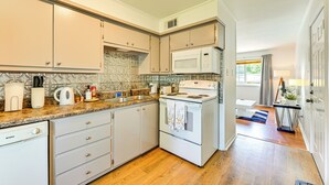 A kitchen with white cabinets, a microwave, a stove, and a sink. - 2 Mi to Historic Dtwn Nacogdoches: Cozy Apartment! (Nacogdoches)