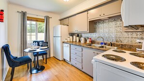 A compact kitchen with a dining area, white appliances, and patterned backsplash. - 2 Mi to Historic Dtwn Nacogdoches: Cozy Apartment! (Nacogdoches)