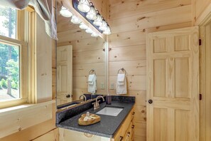 A wooden cabin bathroom with a double sink, a mirror, and a window. - 4 Mi to Fall Branch Falls: Peaceful Cabin w/ Deck (Cherry Log)