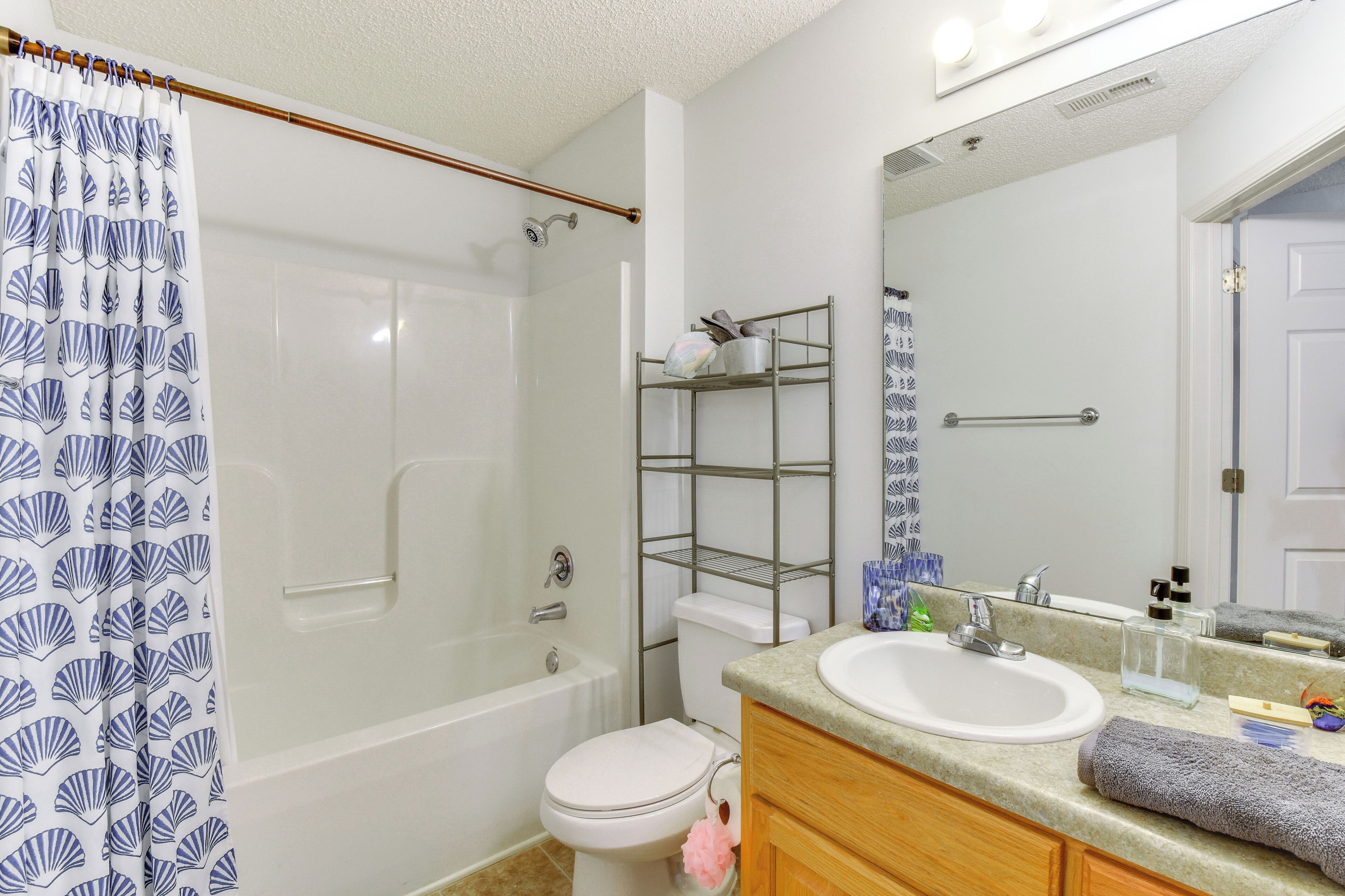 A bathroom with a bathtub, toilet, and sink.