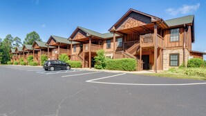A row of wooden cabins with balconies and a parking lot in front. - Scenic Outdoor Space: Lake Keowee Retreat! (Six Mile)