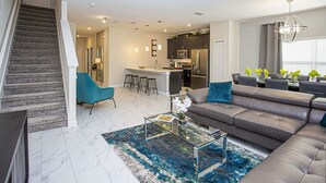 Ein modernes Wohnzimmer mit einer Couch, einem Couchtisch und einer Treppe.