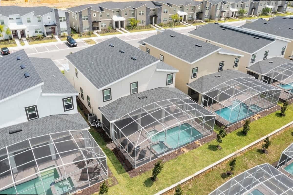 A residential area with modern houses, each featuring a covered outdoor swimming pool.