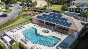 Un immeuble résidentiel doté d’une piscine, de panneaux solaires et d’une terrasse clôturée.