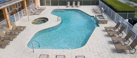 Ein Pool mit ungewöhnlicher Form, umgeben von Liegestühlen und einer Sonnenterrasse.