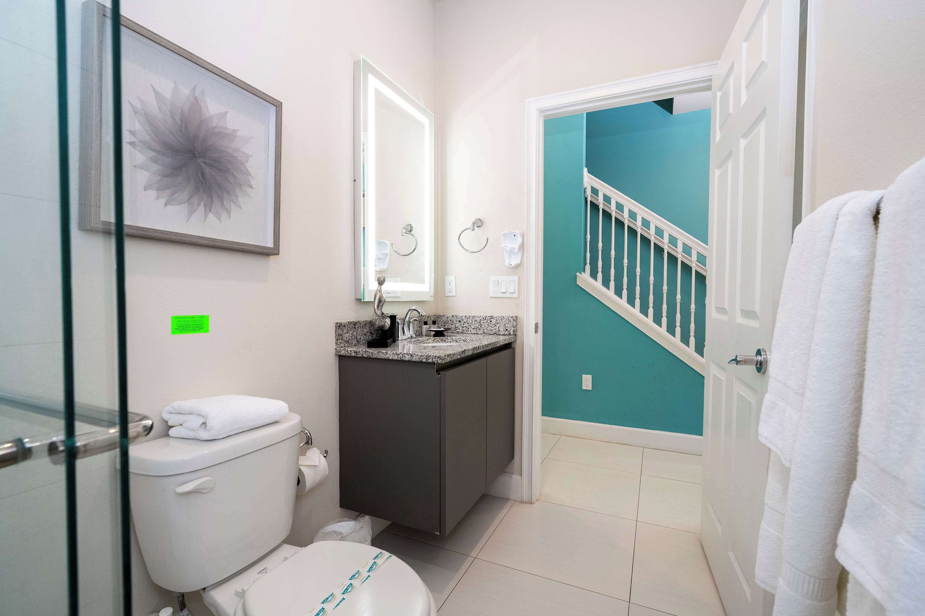 A bathroom with a toilet, sink, and mirror.