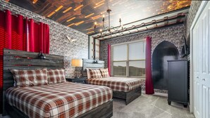 A bedroom with two beds, a brick wall, a wooden ceiling, and a fireplace. - Themed 5Bd Family Villa w Pool Spa Near Disney (Kissimmee)