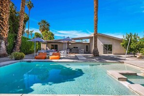 A modern house with a swimming pool, outdoor furniture, and palm trees. - Modern Paradise at Sonora (Palm Desert)