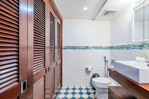 Et badeværelse med toilet, håndvask og bruser.