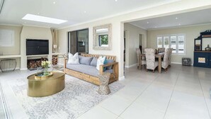 A spacious living area with a sofa, coffee table, and dining table. - Spacious Sunningdale Retreat With Poolside Charm (Cape Town)