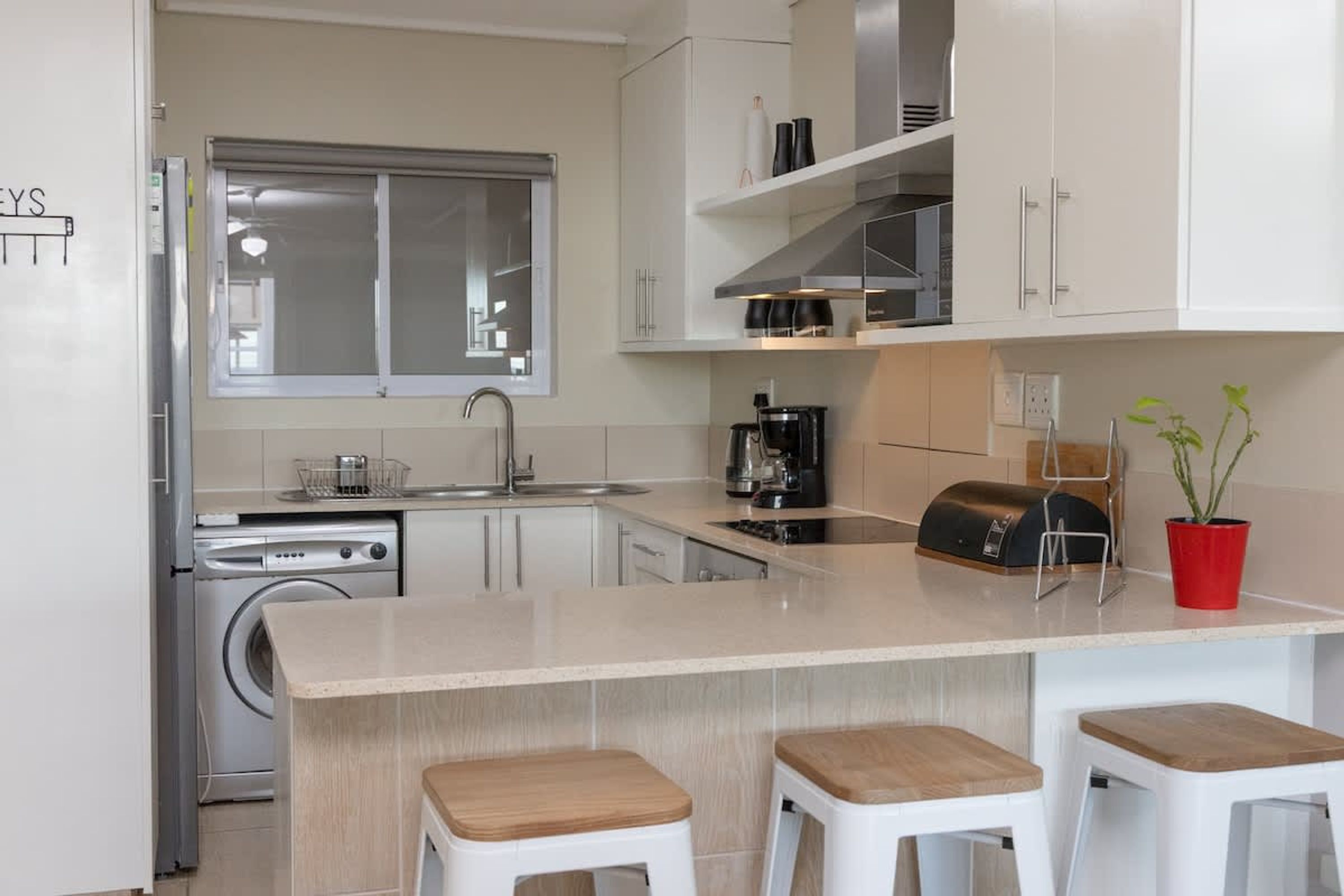 A modern kitchen with a central island, stainless steel appliances, and white cabinetry.